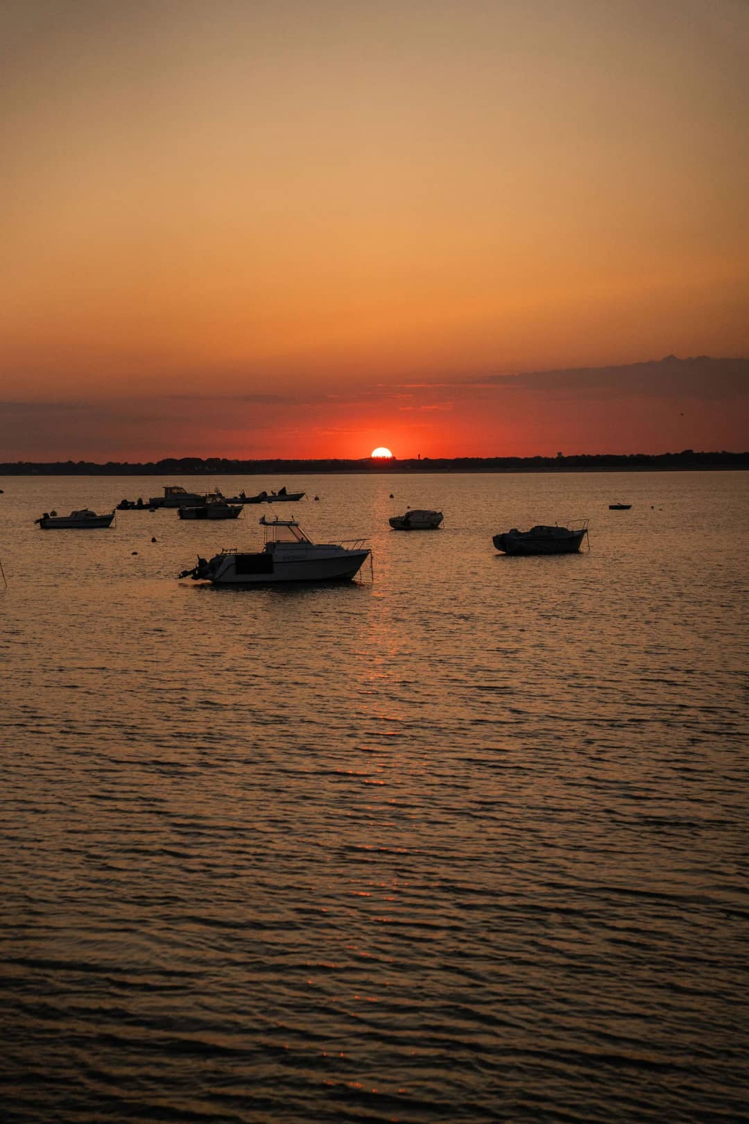 Zonsondergang boven het water met bootjes