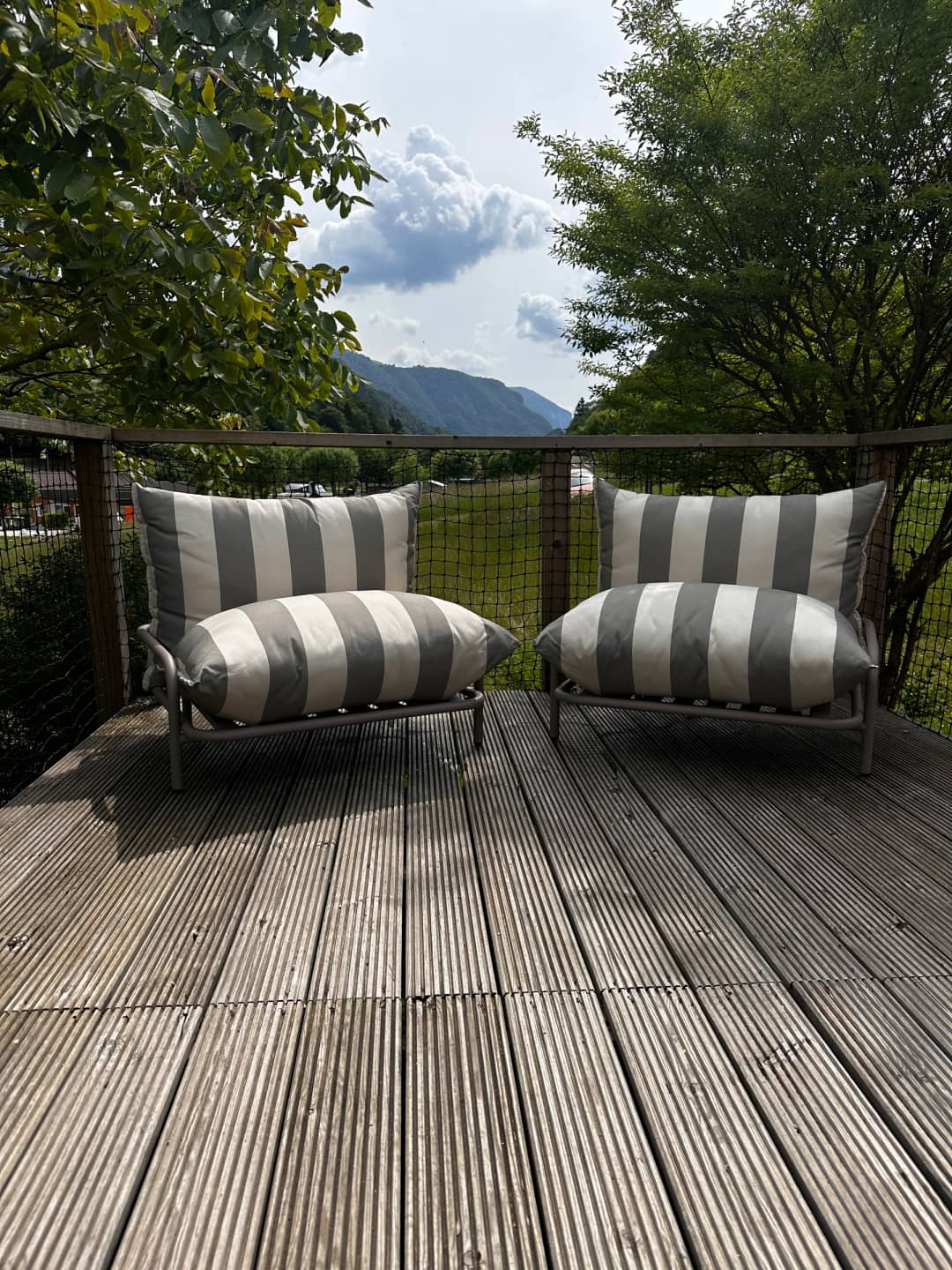 Terras van de Big Oak Lodge XS met twee loungestoelen en uitzicht op de bergen