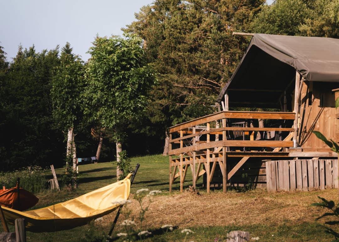 Base Lodge met houten terras en hangmat tussen de bomen