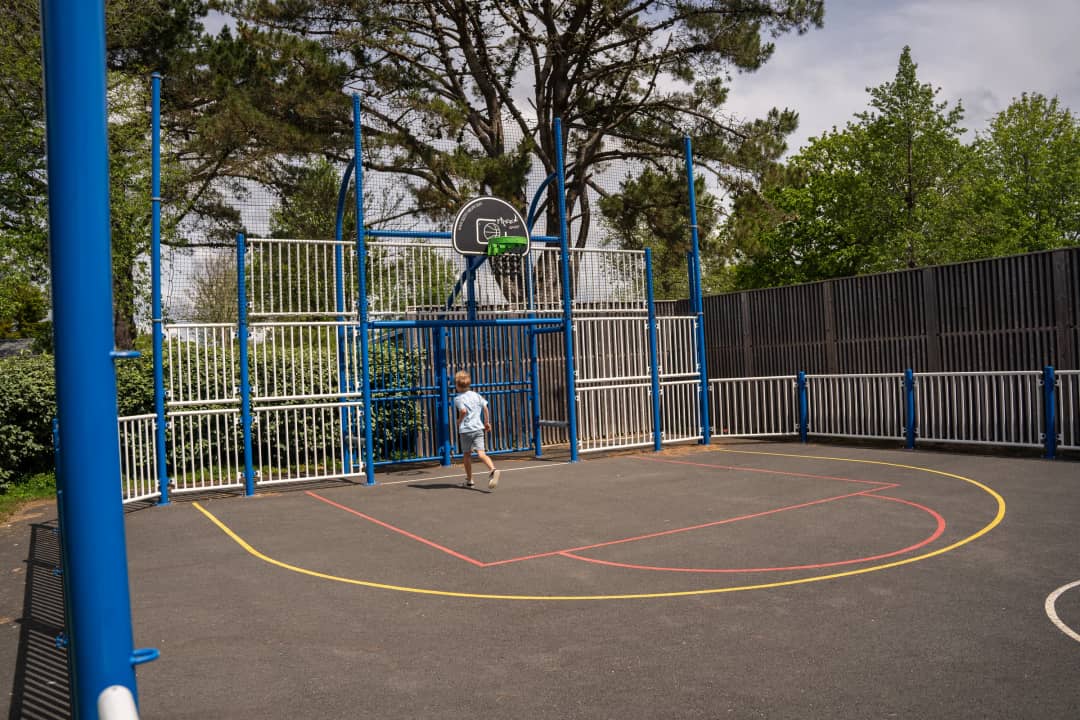 Sportveld met basketbalpaal op de camping